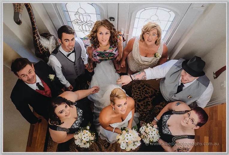 Teigan and her family huddle laughing on the entry floor in an overhead group portrait