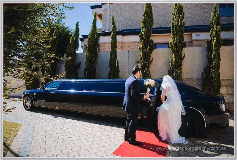 Teigan steps from a black limousine onto a red carpet as the chauffeur holds the door