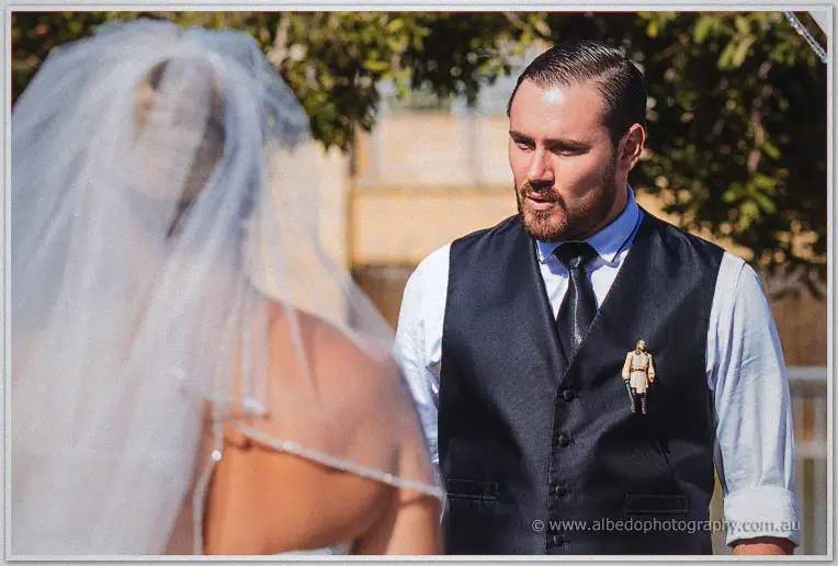 Troy's eyes glisten as veiled Teigan reaches him at the garden ceremony arbour