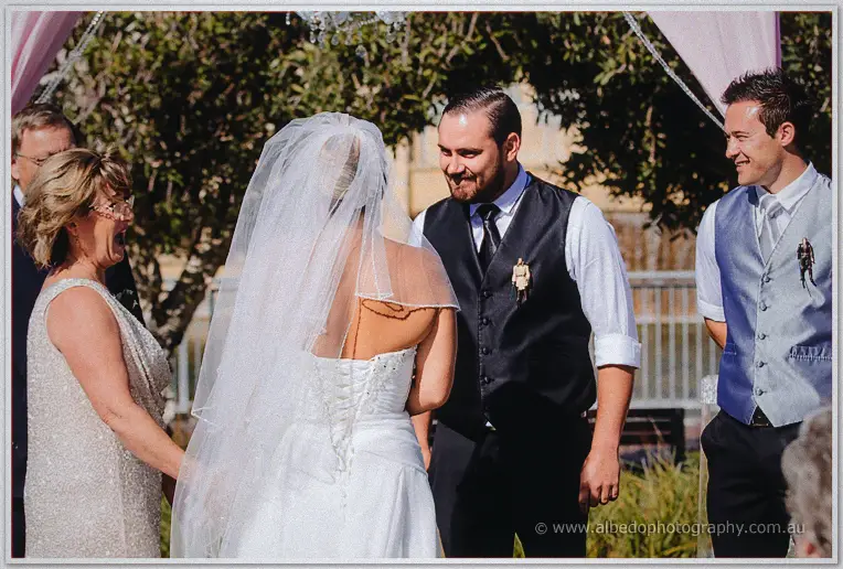Teigan joins laughing Troy at the arbour as her mother and guests beam in sunlight