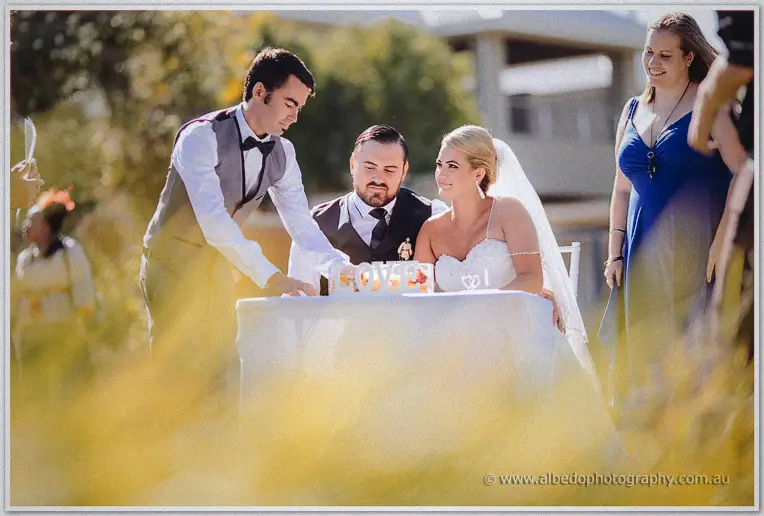 Troy and Teigan sign the marriage register at a white table in warm garden light