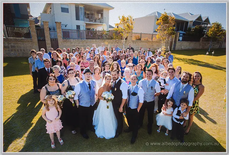 Wide group shot of every guest with the newlyweds on the Hillarys garden lawn