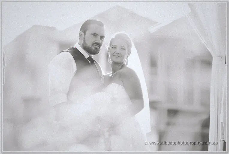Dreamy double exposure blends the newlyweds with their white marquee setting