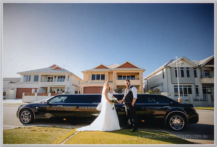 Troy and Teigan hold hands before their black stretch limousine in the evening sun