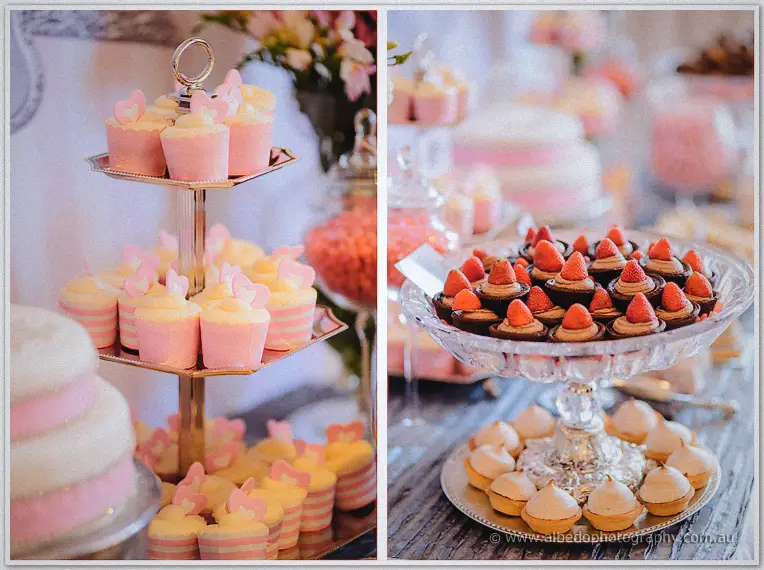 Pink heart cupcakes on a gold tiered stand beside chocolate strawberry tartlets
