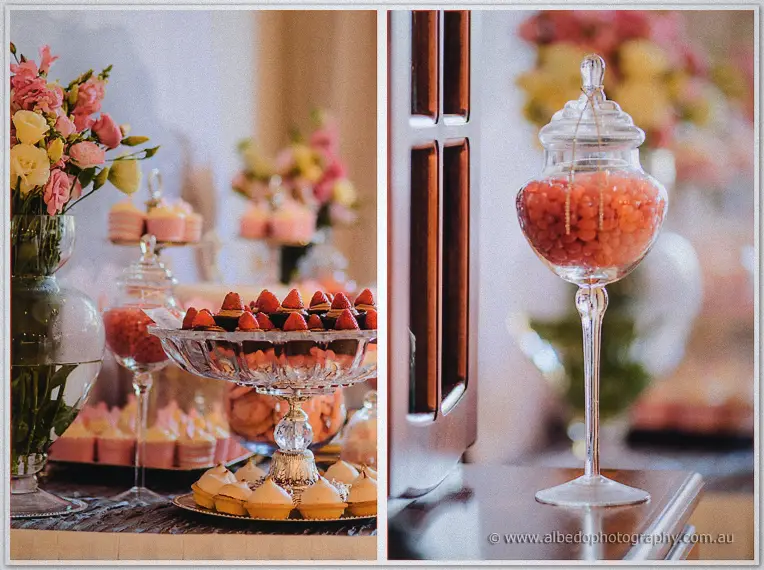 Strawberry tarts and pastel sweets in apothecary jars with pink blooms behind
