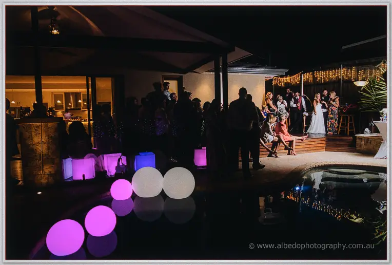 Glowing pink and white pool orbs float before guests gathered for speeches on the deck