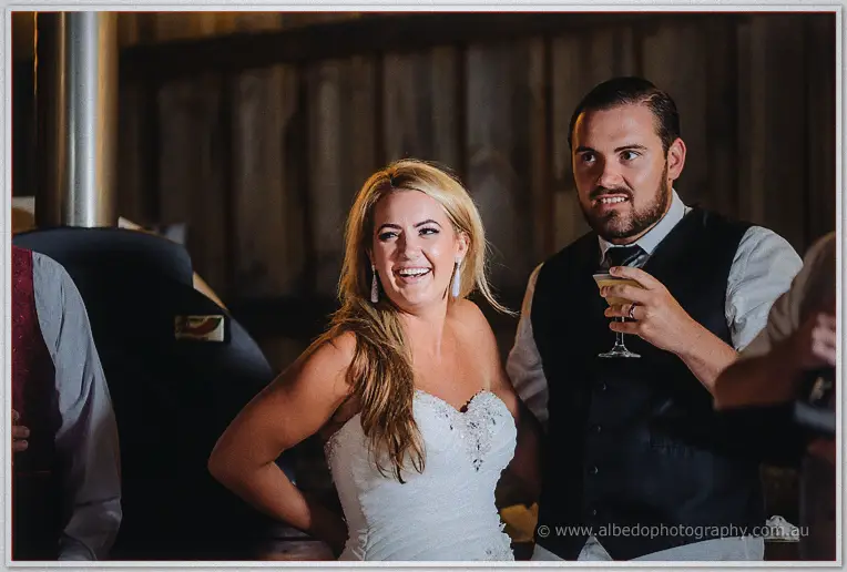 Teigan laughs hard beside Troy holding his drink during the reception speeches
