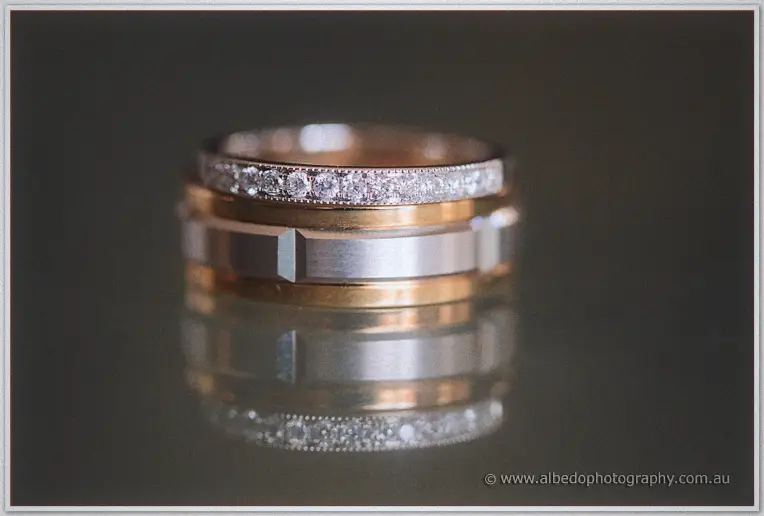 A diamond-set band stacked on Michael's striped gold and silver wedding ring catches the light.