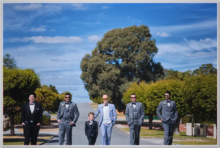 Michael walks arm in arm with his page boy down a tree-lined suburban street.