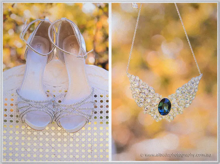 Rhinestone bridal heels on a cane chair beside a crystal wing necklace with sapphire, golden autumn bokeh