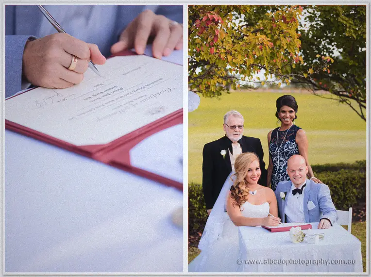 Signing the marriage register beside family under a tree with autumn leaves.