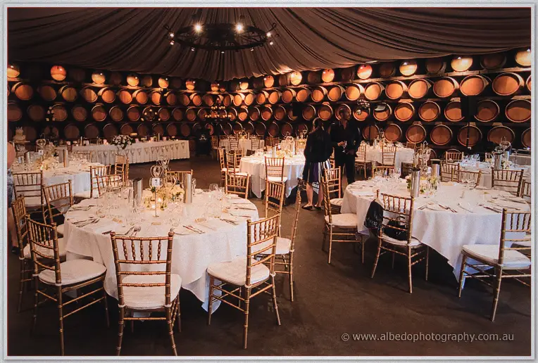 Round tables dressed in white fill the barrel-walled reception cellar at Sandalford Wines.