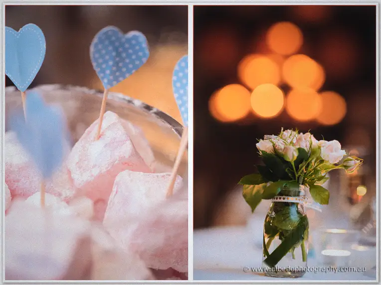 Pink Turkish delight dotted with blue hearts beside a tiny rose jar against golden bokeh.