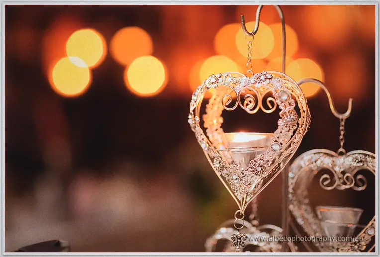 Silver heart lanterns glow against warm amber lights in the reception room.