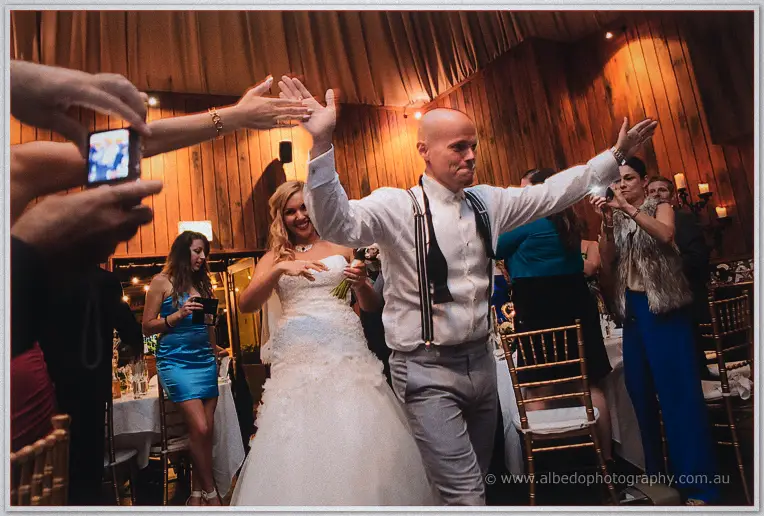 Michael high-fives guests down the aisle as Jasmine beams behind him.