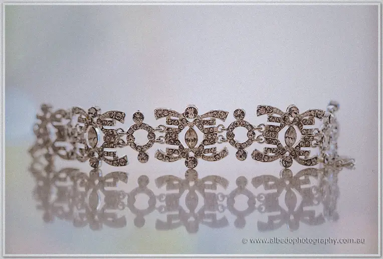 Art deco crystal bridal bracelet mirrored on a pale reflective surface in soft light