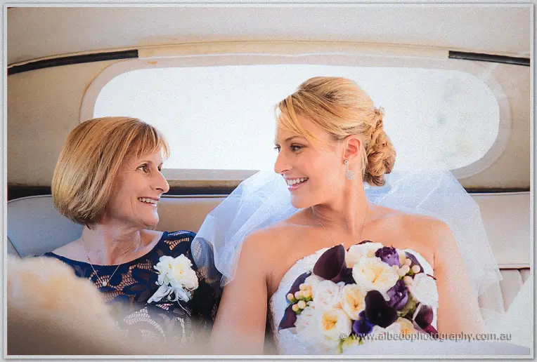 Lauren and her mother share a smiling moment in the back seat of the wedding car