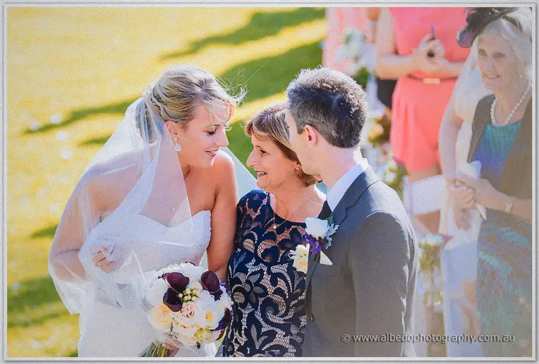 Lauren greets Ryan and her mother at the altar, sunlight washing the lawn behind