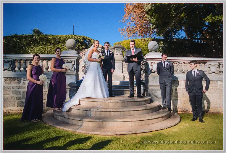 Lauren and Ryan wed on the curved stone steps, party and celebrant gathered around