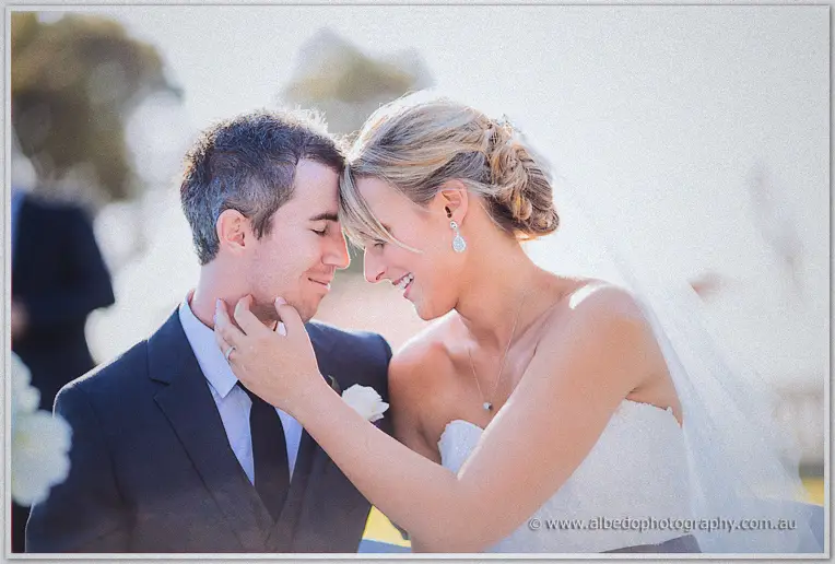 Lauren cups Ryan's face as the two touch foreheads in soft afternoon light