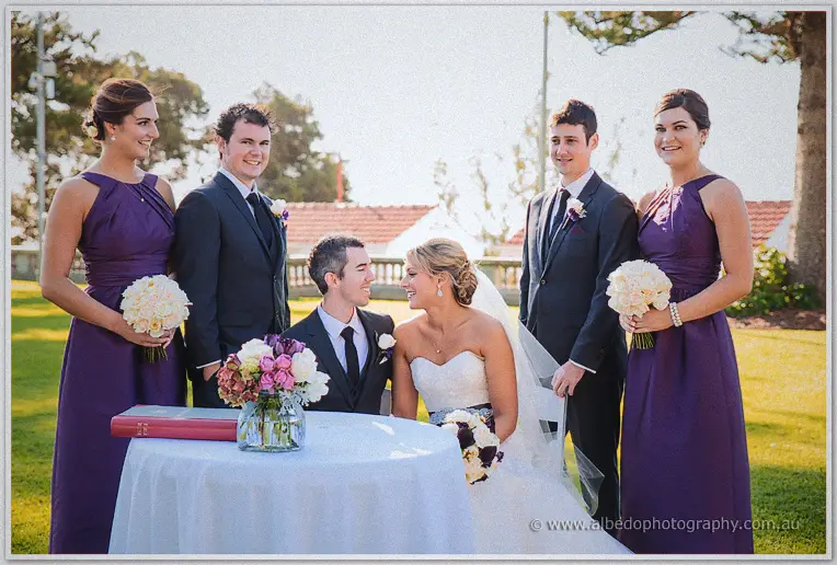 The wedding party gathers around the signing table after the ceremony