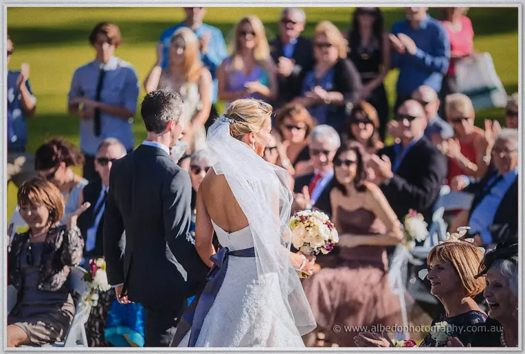 The newlyweds walk back down the aisle to applause from smiling guests