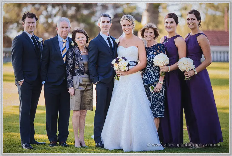 Lauren and Ryan pose with their parents among the gardens in golden light