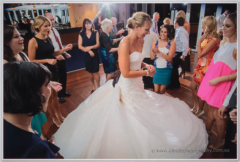 Lauren twirling her huge skirt in the middle of a cheering guest circle on the timber dance floor