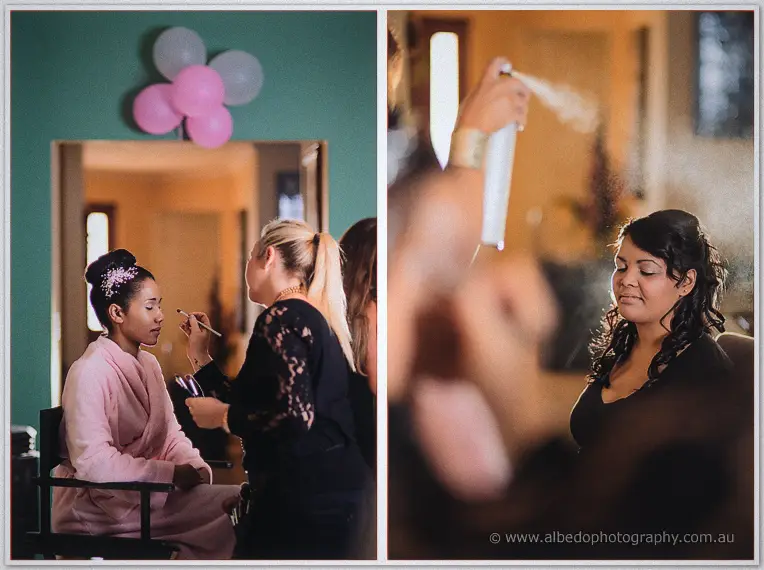 A makeup artist works on the bride amid balloons while hairspray mist drifts through the morning light