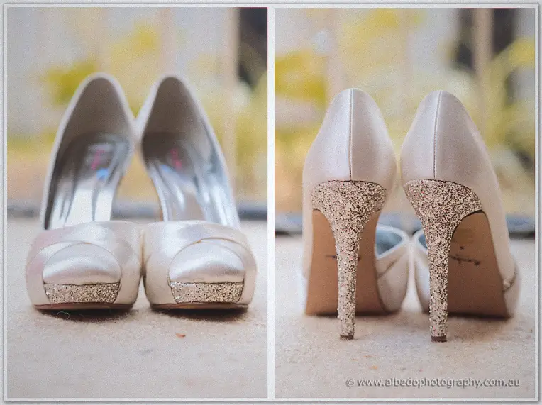 Cream satin peep-toe heels pictured from front and back, their stiletto heels glittering, in soft window light