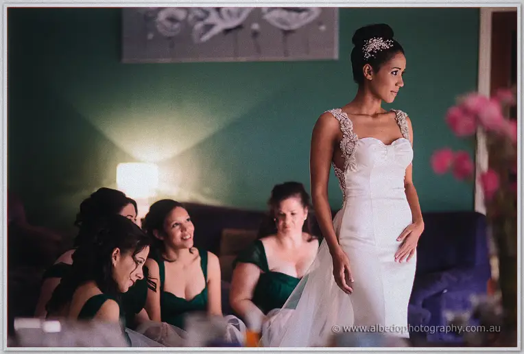 Cristal stands ready in her beaded gown as her bridesmaids in green turn to take in the reveal