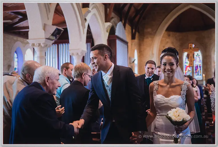 Troy shakes hands with a congratulating elder as he and Cristal leave the church to warm applause.