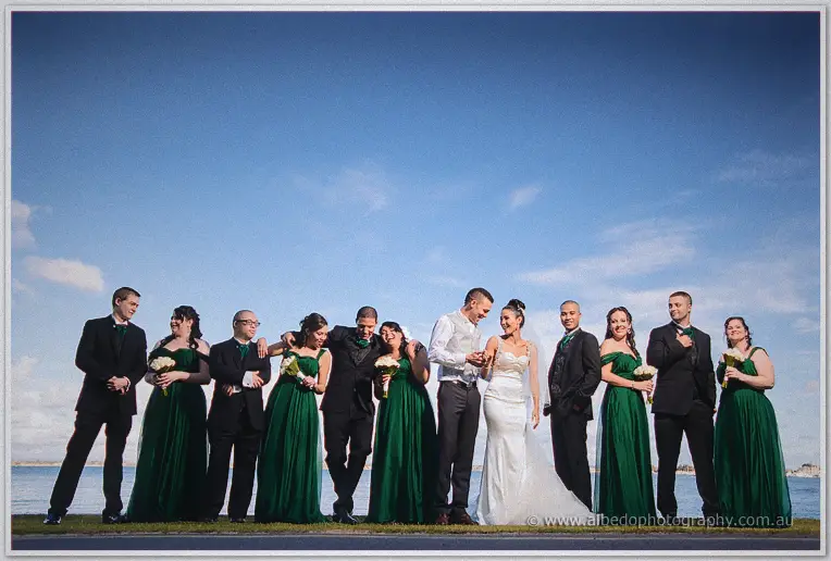 The wedding party dissolves into laughter along the river foreshore as Troy grips Cristal's hand.