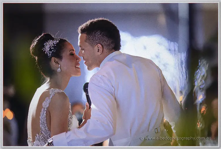 Nose to nose, Cristal and Troy share one microphone in the warm haze of their first dance.