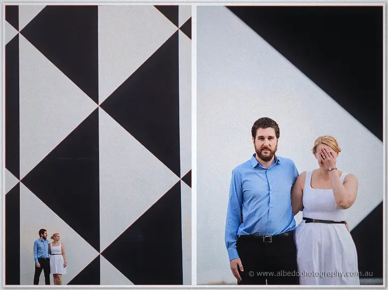 Before a bold geometric mural, Dale looks on as Julie covers her face in laughter