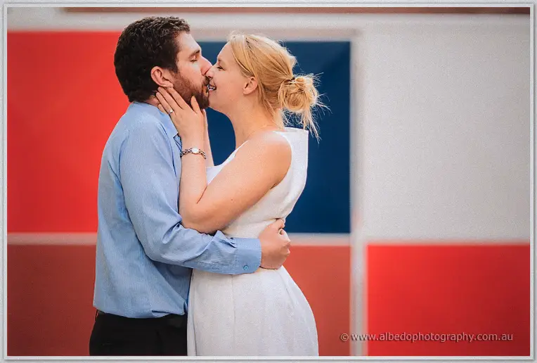 A tender kiss in front of bold red and blue panels, Julie's hand on Dale's cheek
