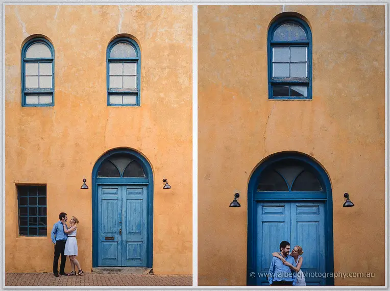Two wide frames of the pair embracing before a tall arched door on a golden wall