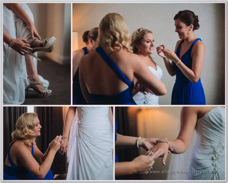 Bridesmaids buckle Olivia's heels and fasten a sparkling bracelet on her wrist in warm room light.