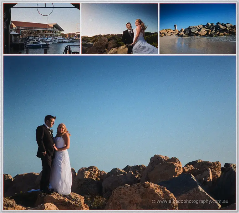Olivia and Max pose on sunlit harbour rocks by the Hillarys marina, boat sheds and a lighthouse behind.
