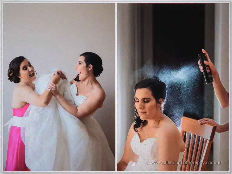 Sarah and a bridesmaid laugh while straightening the gown; hairspray mist settles over her styled curls.