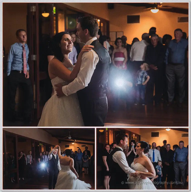 Sarah dances joyfully with Chris as guests pack the floor, camera flashes glowing behind them.