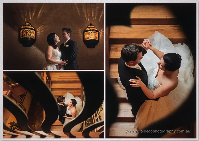 Sarah and Chris dance on a timber staircase under lantern light, framed through the sweeping balustrade.