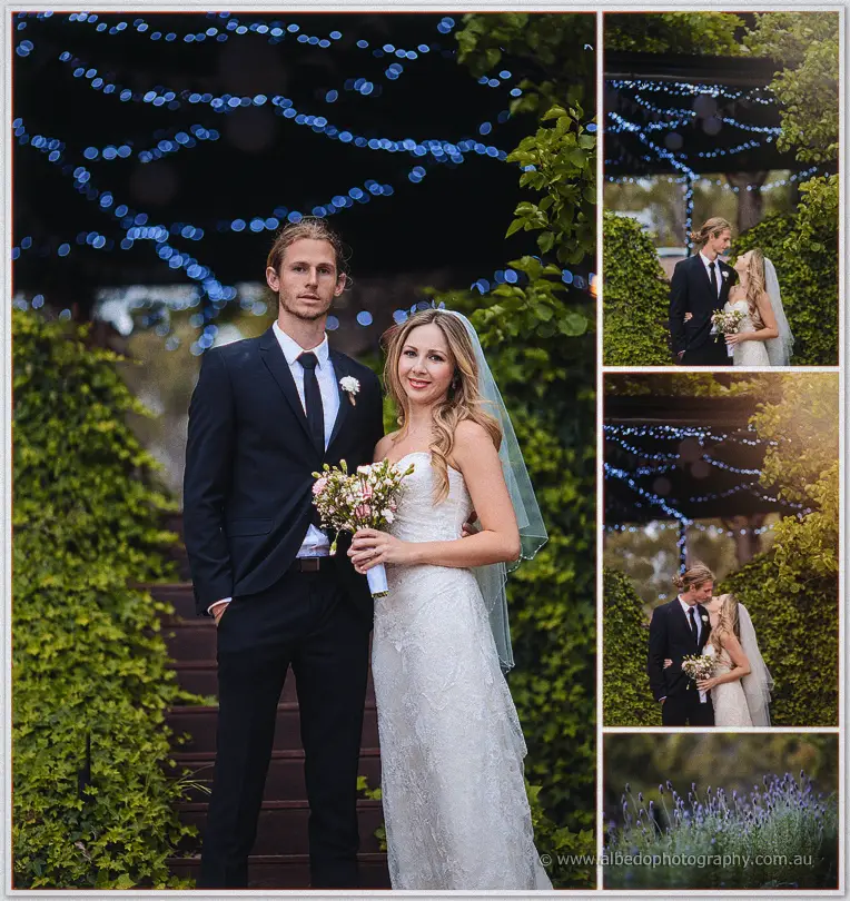 Tara and Stephen stand beneath glowing blue fairy lights, her pink bouquet in hand, ivy climbing behind