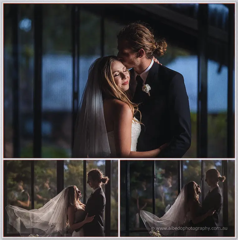 Stephen kisses Tara's forehead inside the glasshouse as her veil drifts in the low evening light