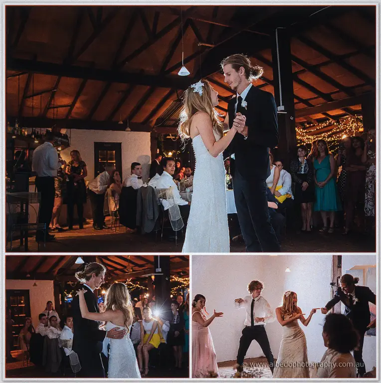Tara and Stephen share their first dance in the barn as guests watch from candlelit tables