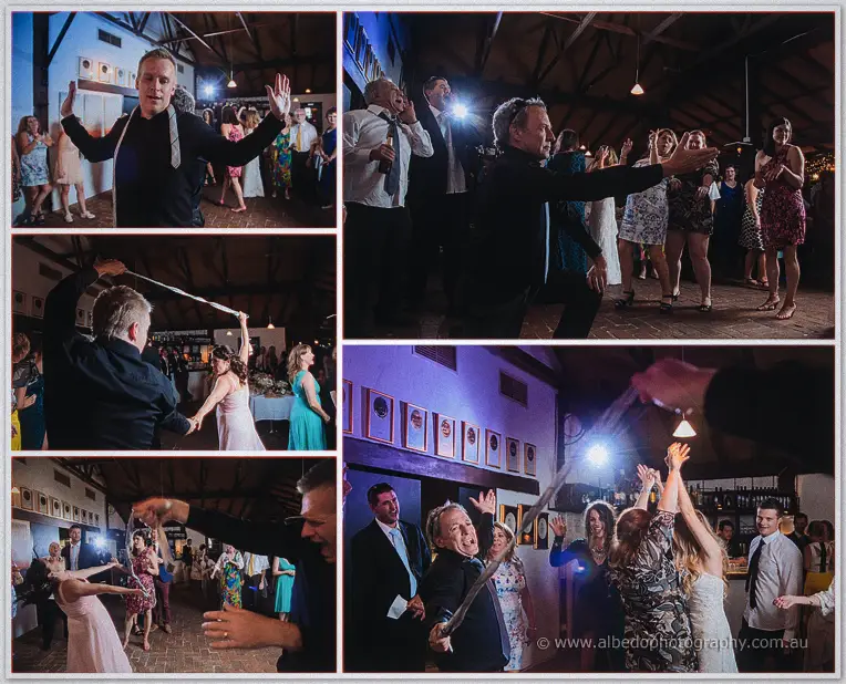 Guests swing ties and dance wildly across the barn floor under warm festoon lighting