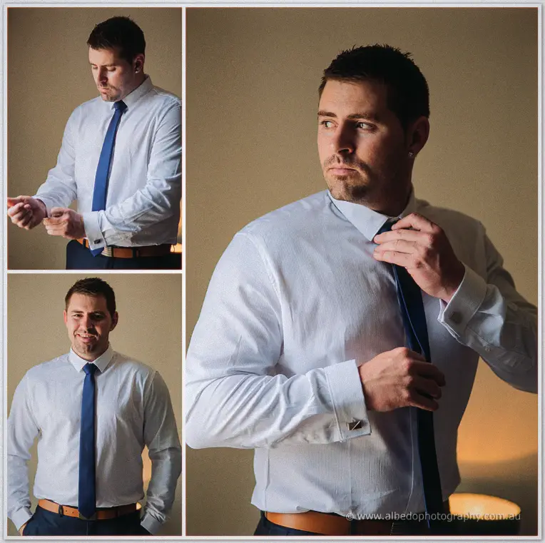 Lee fastens his cufflinks and adjusts his navy tie by lamplight, quiet and composed before the ceremony.