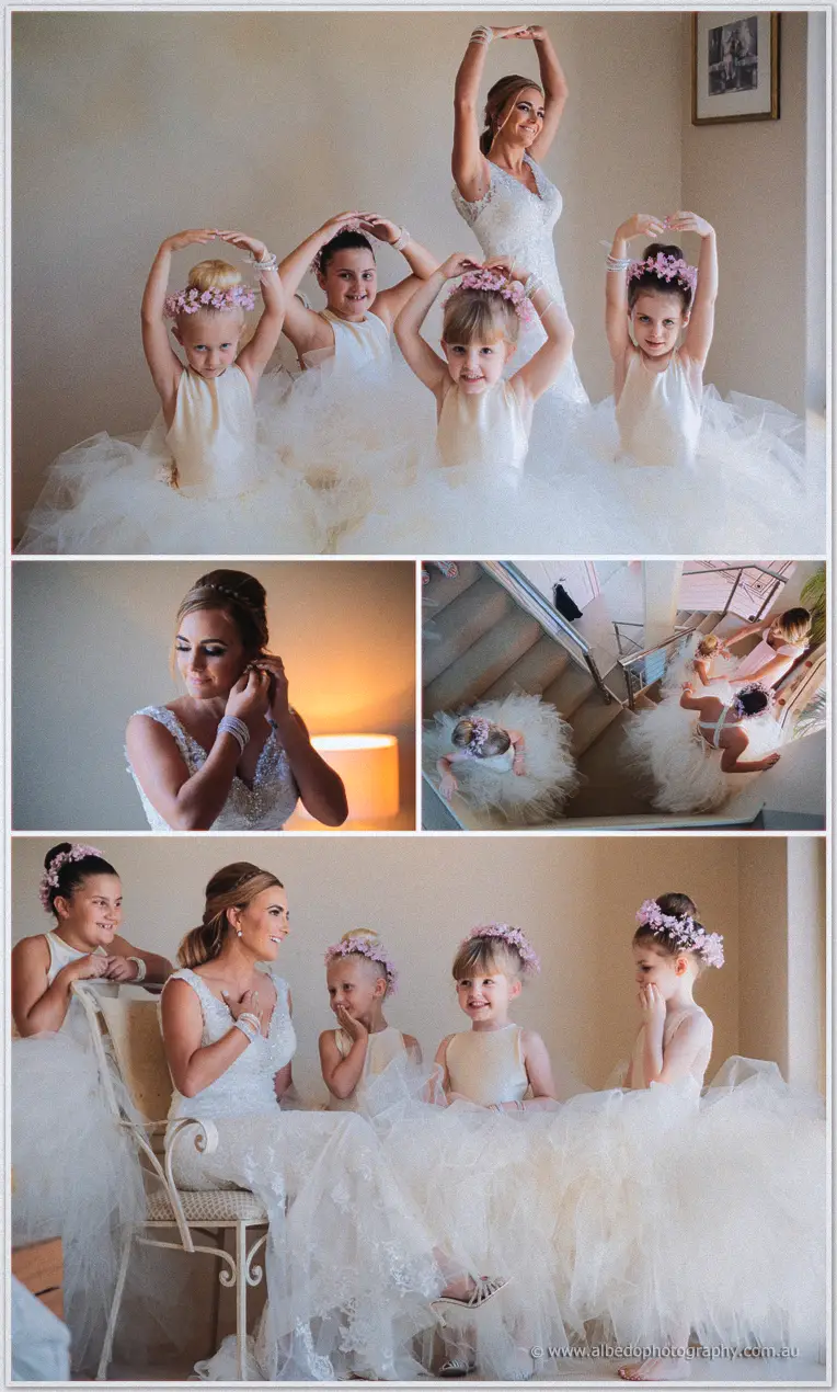 Tarmecca poses with flower girls raising blossom-crowned arms, their tulle skirts filling the frame.