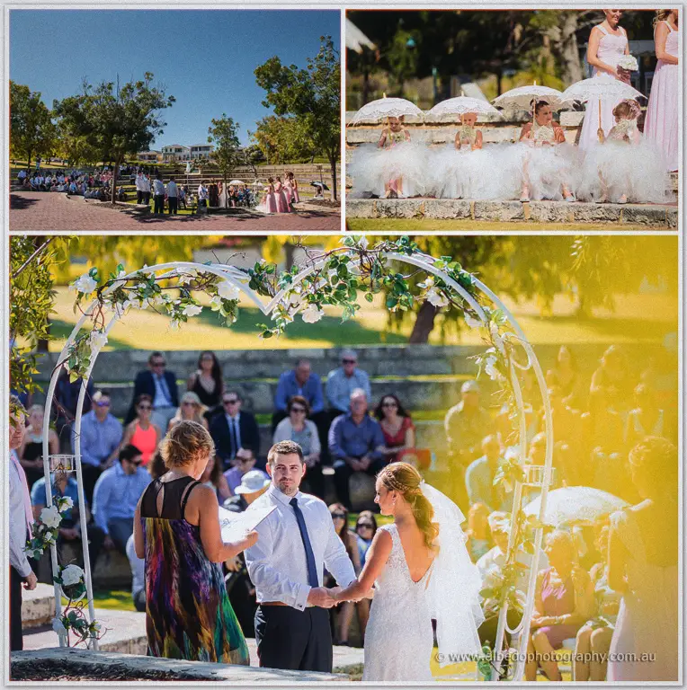 An officiant reads as Lee and Tarmecca face one another under the white rose arch in the park.